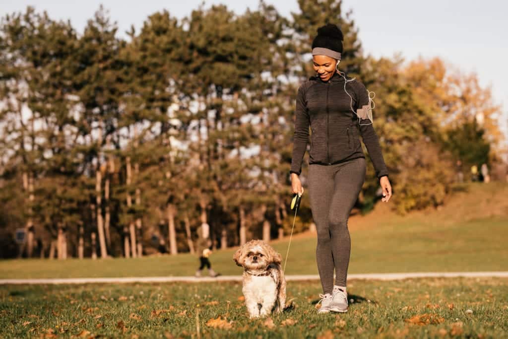 Benefits of Walking Your Pet Woman happy walking her dog.